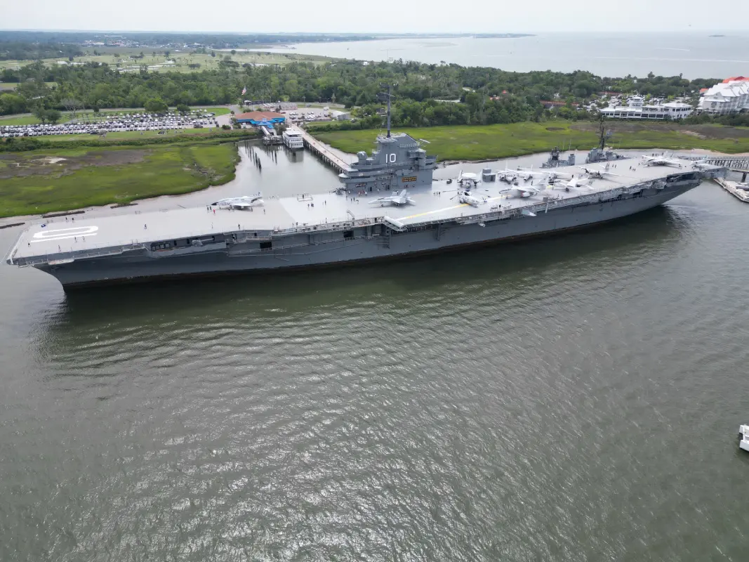 A large aircraft carrier is in the water.