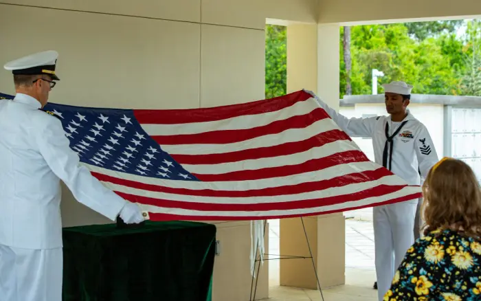 A man holding an american flag in front of a building.