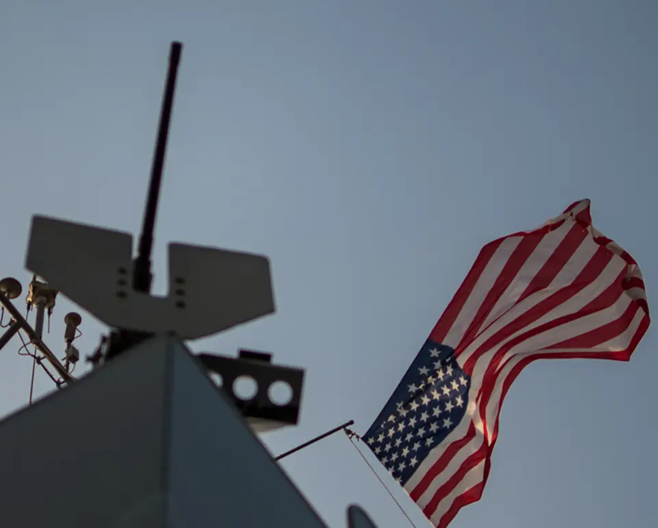 A flag flying on top of an aircraft carrier.