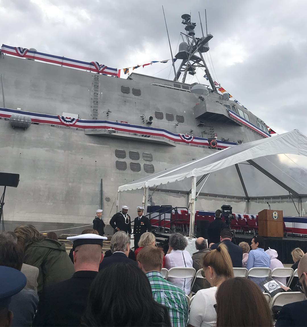 A crowd of people standing around a large ship.